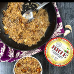 Aerial view of a pan and white bowl with keto mushroom cauliflower risotto and a box of brie and text.