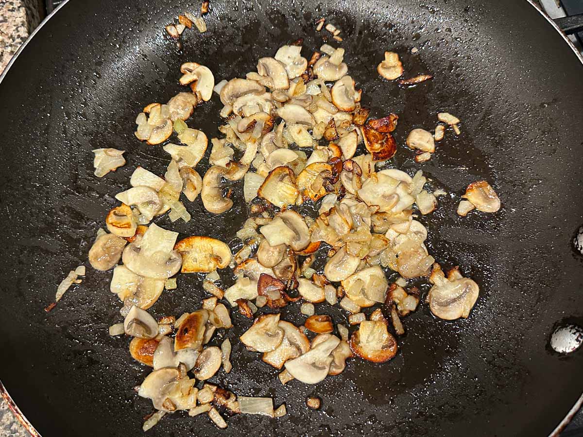 Pan with sautéed onions and mushroom slices.