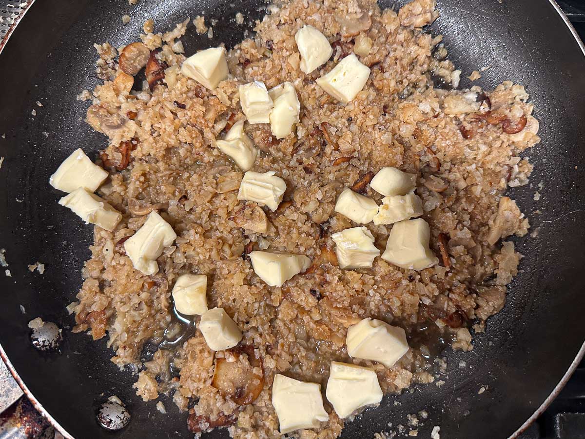 Pan with the pieces of brie added to the dish.