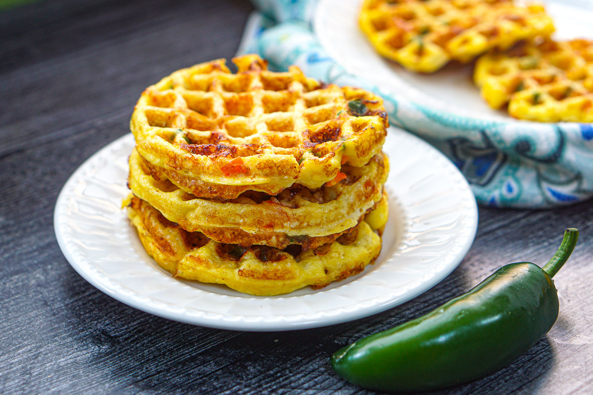 white plate with a stack of jalapeño cheddar waffles