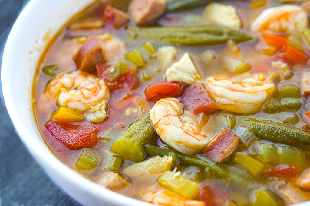 closeup of cajun soup with shrimp, kielbasa, veggies and okra