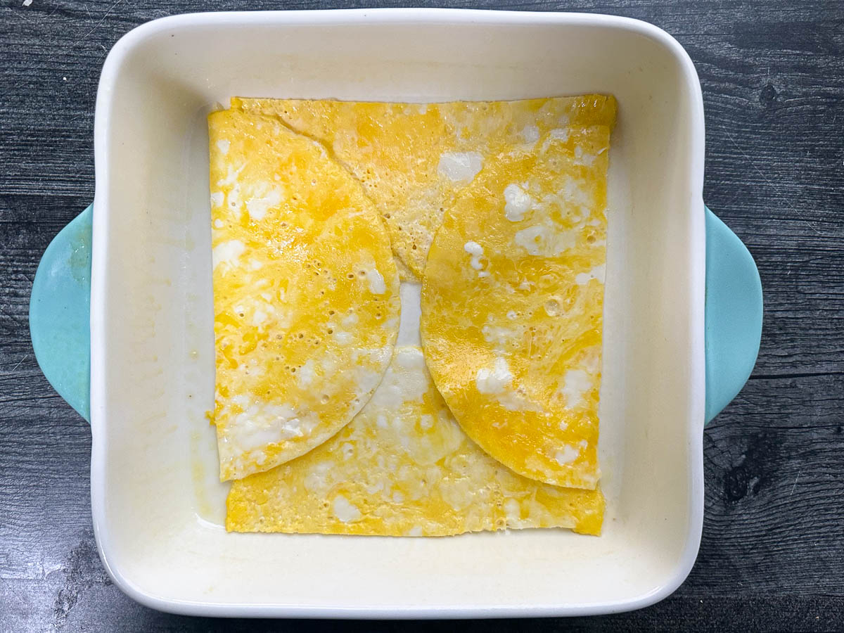 baking dish with first layer of egg crepes