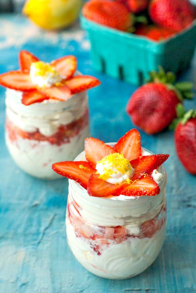 closeup of no bake strawberry cheesecake jars with strawberry slices that form a flower on top