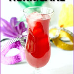 Glass with low carb hurricane drink and Mardi Gras masks in the background and text.