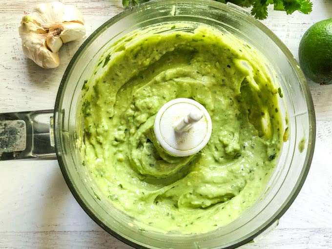 food processor bowl with creamy avocado lime dressing