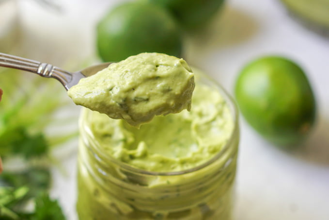 spoonful of creamy avocado lime dressing and a jar