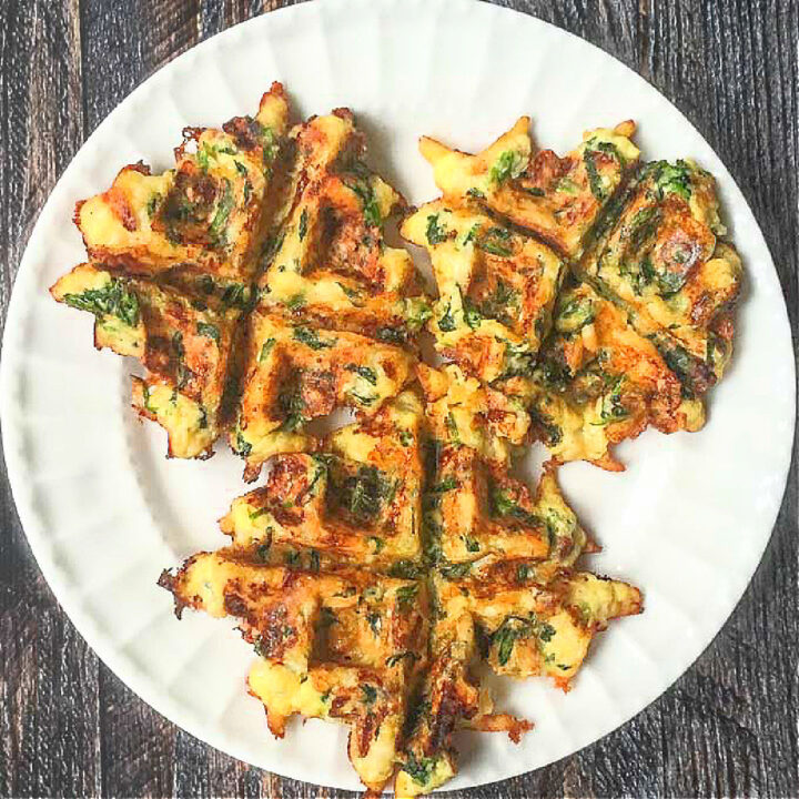 A white plate with 3 small low carb spinach waffles.