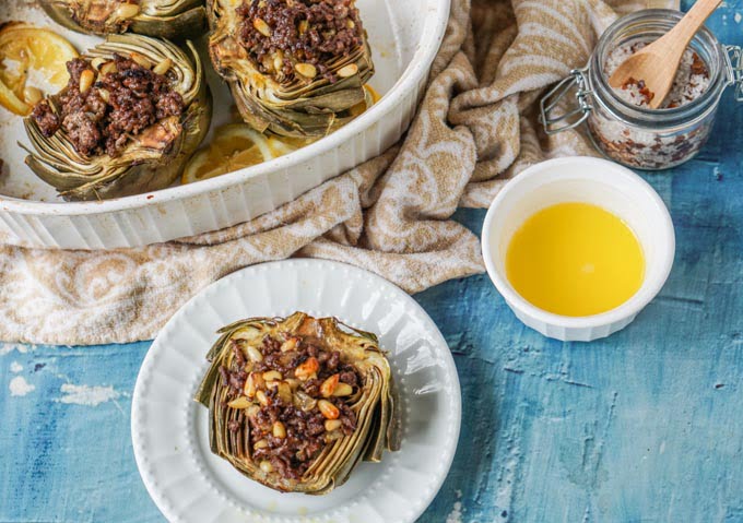 These meat stuffed artichokes are a delicious low carb dinner. The meat stuffing has mediterranean flavors of cinnamon and lemon with crunchy pine nuts. Enjoy artichokes in season with this easy dinner. 