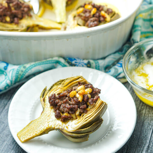 meat stuffed artichoke on white plate