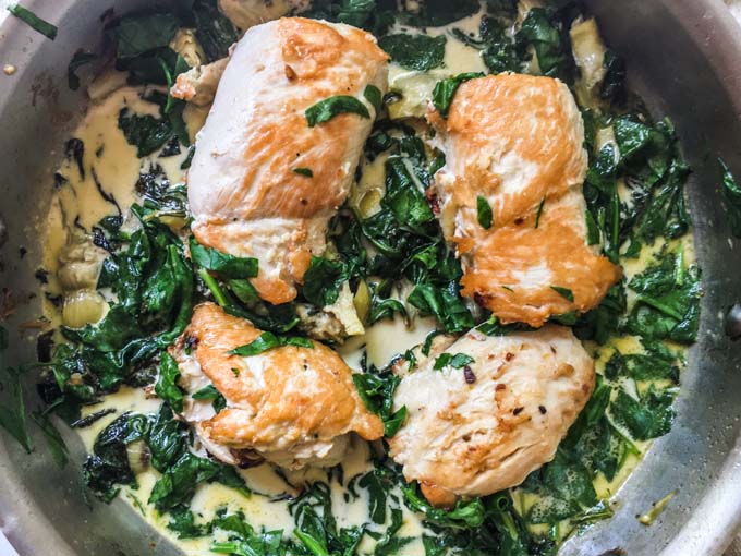 This tapenade stuffed chicken with creamy spinach & artichokes dish is a deliciously low carb dinner you make in one pan. The creamy spinach and artichokes go perfectly with the tasty tapenade that the chicken is stuffed with and each serving is just 4.7g net carbs.