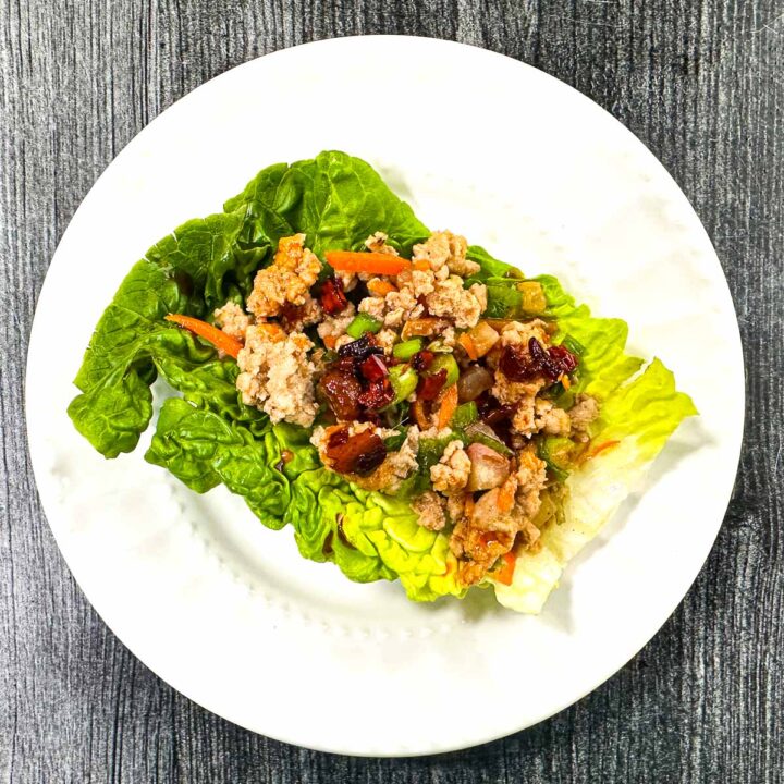 A small white plate with a serving of the Asian keto chicken lettuce wraps.