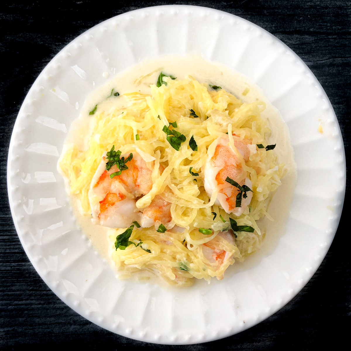 white plate with keto coconut basil spaghetti squash with shrimp