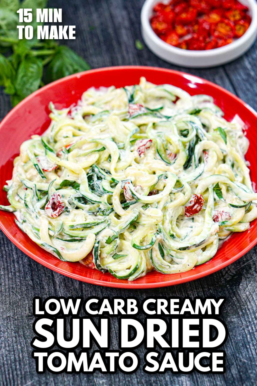 Aerial view of a red plate with keto creamy sun dried tomato sauce covered zucchini noodles and text overlay.