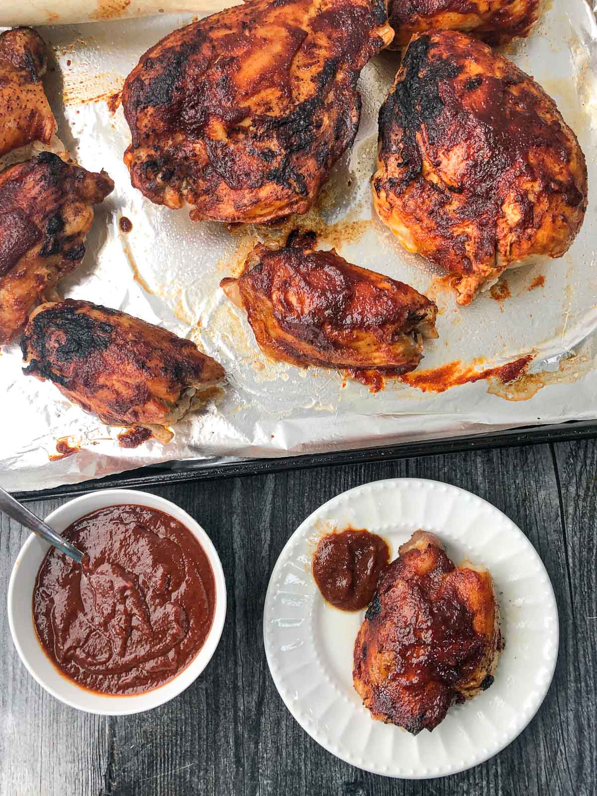 aerial view of cookie sheet and white plate with low carb bbq chicken