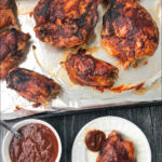 aerial view of cookie sheet and white plate with low carb bbq chicken with text