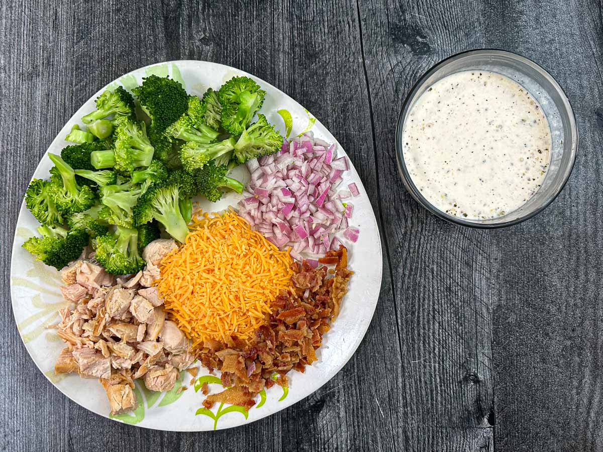 Recipe ingredients - broccoli, red onion, cheddar cheese, cooked chicken, bacon and ranch dressing.