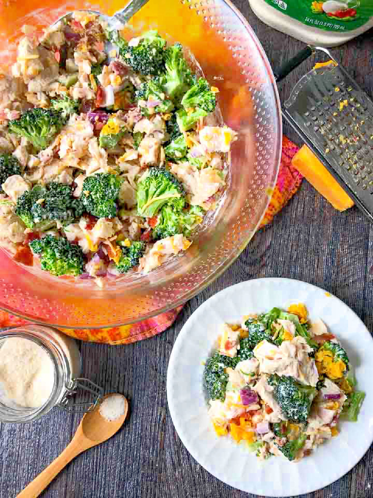 Aerial view of a glass bowl and white plate of keto chicken salad with broccoli and bacon.
