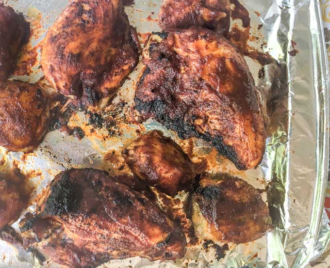 foiled covered cookie sheet with bbq chicken pieces