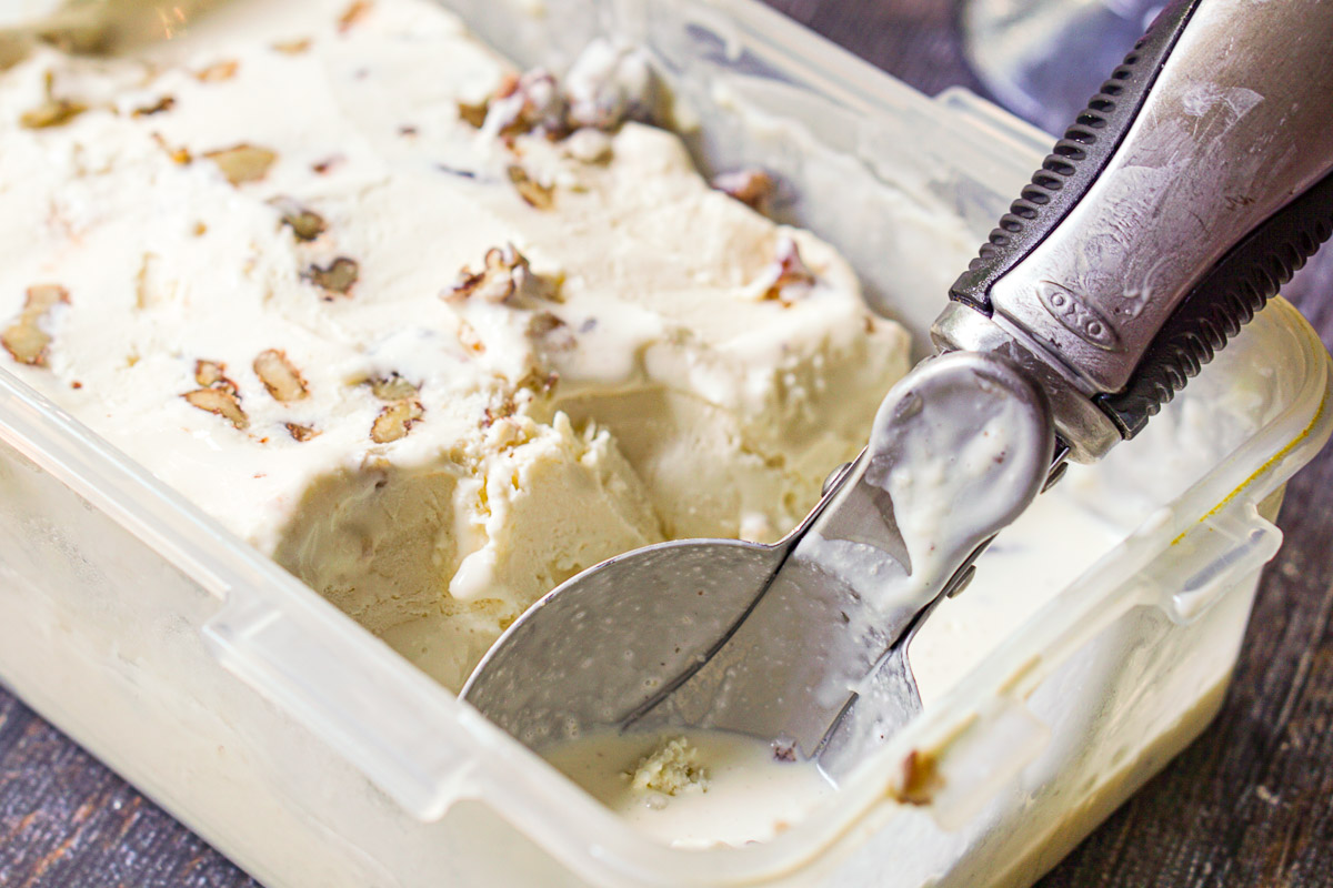 plastic container with low carb butter pecan ice cream and a scooper