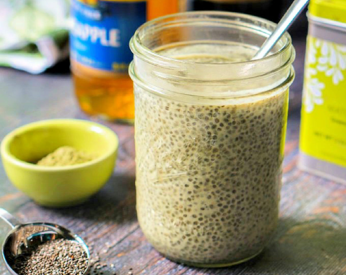A jar with matcha tea chia pudding with protein and a small green bowl with matcha powder in it.
