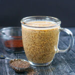 Closeup of a glass coffee cup with coffee chia pudding with protein and a spoonful of chia seeds.