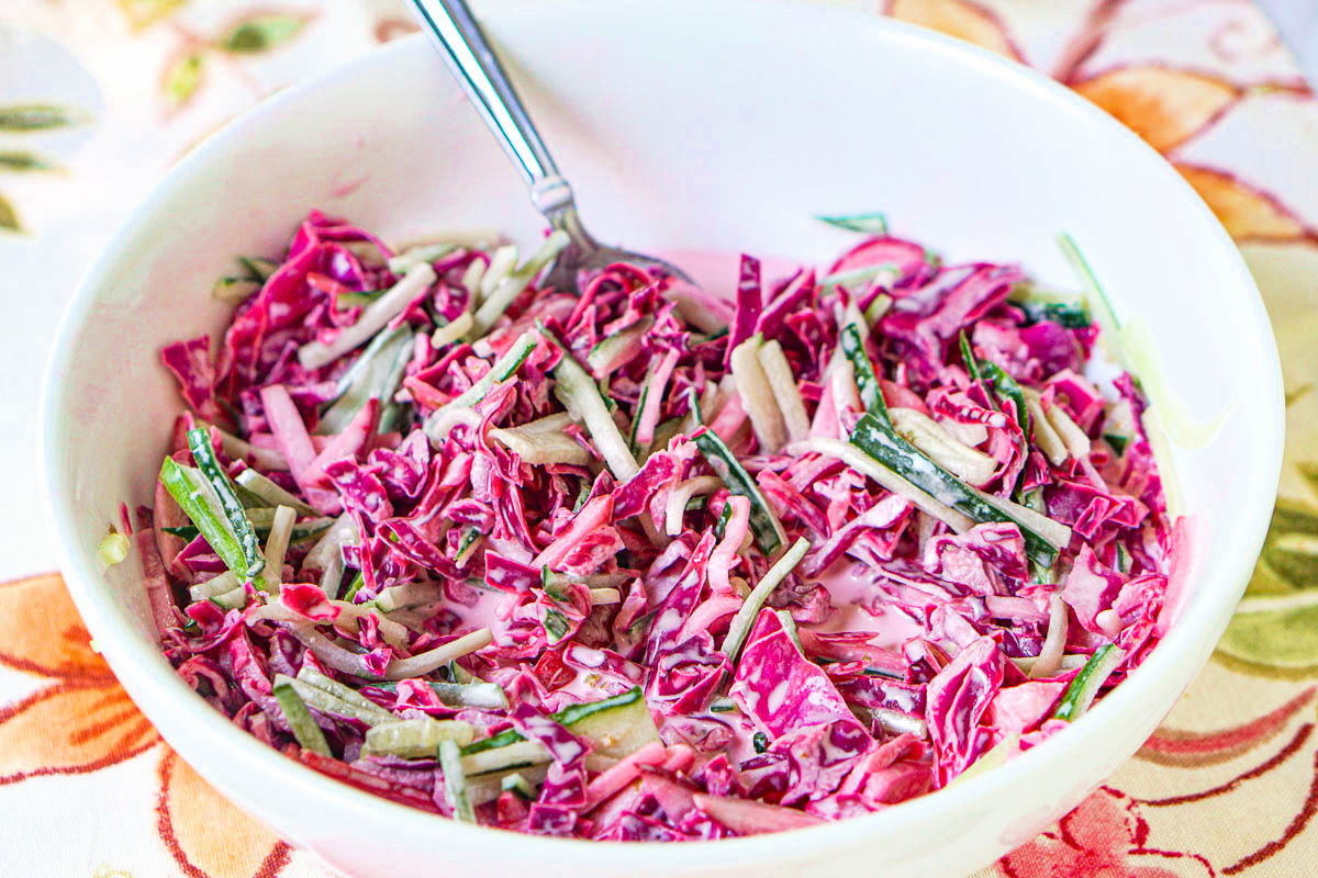 closeup of a bowl of red cabbage salad with creamy dressing