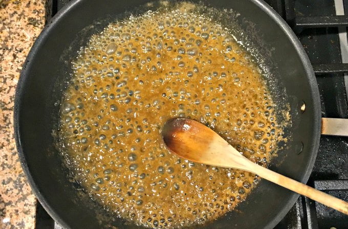 making sugar free caramel sauce in skillet on stove with wooden spoon