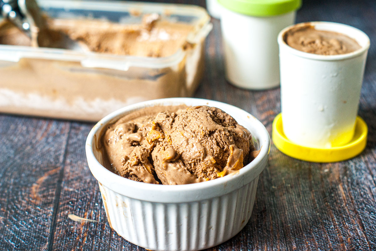 ramekin with a scoop of chocolate ice cream and container in the background