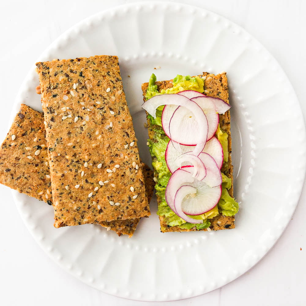 crispbread cracker with avocado and sliced radishes