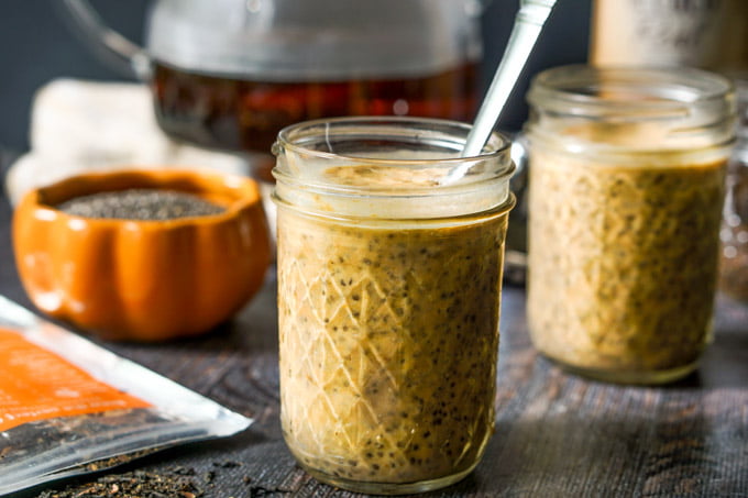 pumpkin chai breakfast chia pudding in mason jars with orange pumpkin dish holding chia seeds