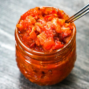 Glass jar with low carb tomato jam with bacon and caramelized onions.