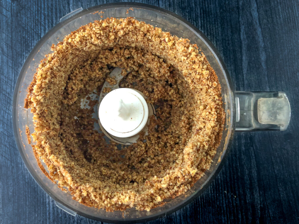 food processor bowl with crushed nuts