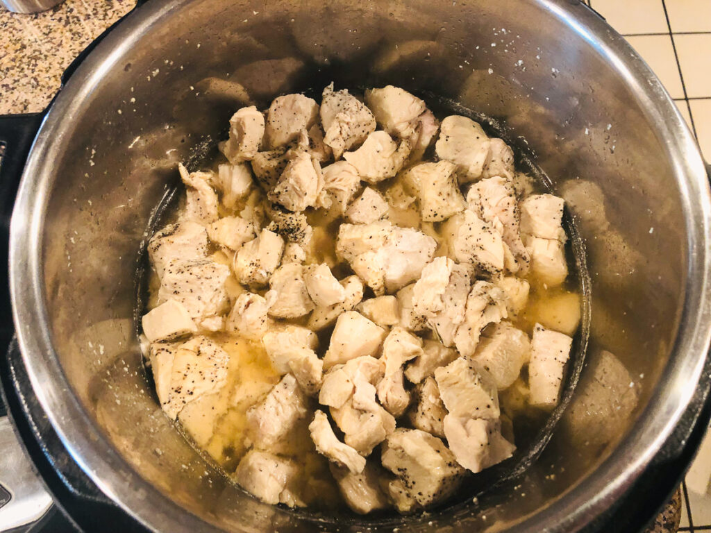 instant pot filled with cooked chicken cubes