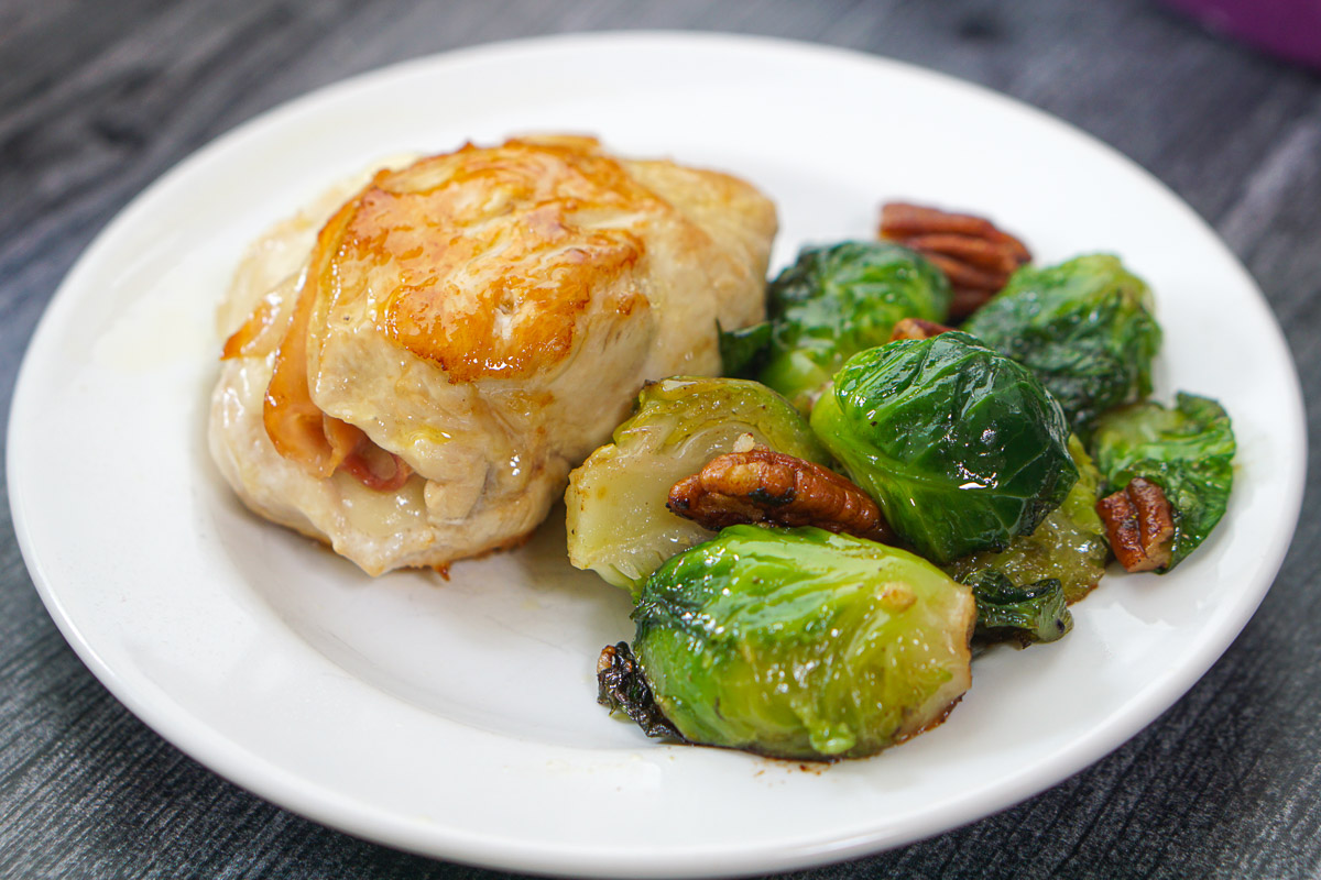 white plate with chicken cordon bleu and Brussels sprouts with pecans