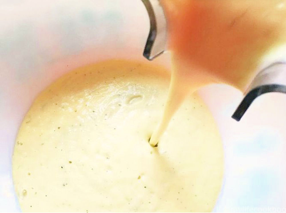 blender pouring cauliflower cream into a bowl