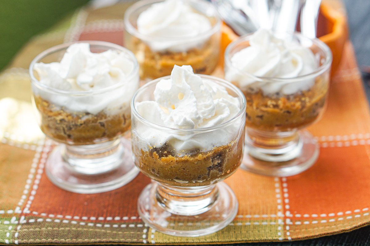4 glass dishes with keto pumpkin pie topped with whipped cream