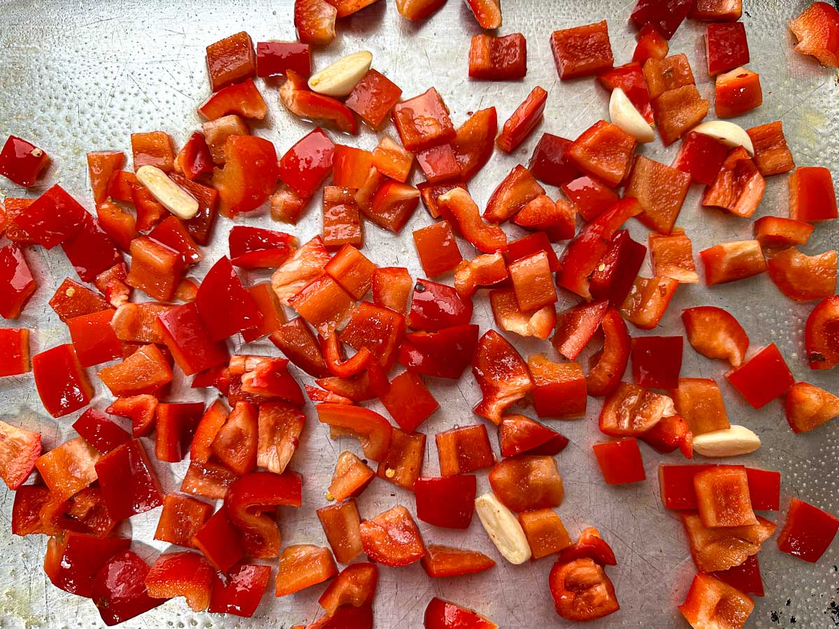 Baking sheet with raw chopped peppers.