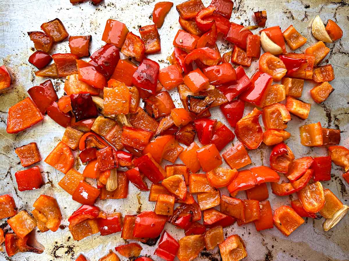 Baking sheet with roasted red pepper chunks.