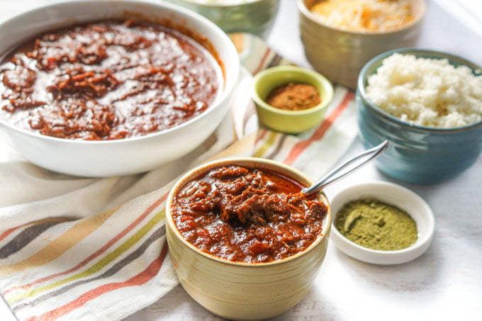 This easy shredded beef chili in the Instant Pot recipe is not only super tasty but very versatile. Eat like you would a bowl of chili or use for quesadillas or burritos. Also tastes great over rice or cauliflower rice. Only 7.1g net carbs and you can also make it in the slow cooker.