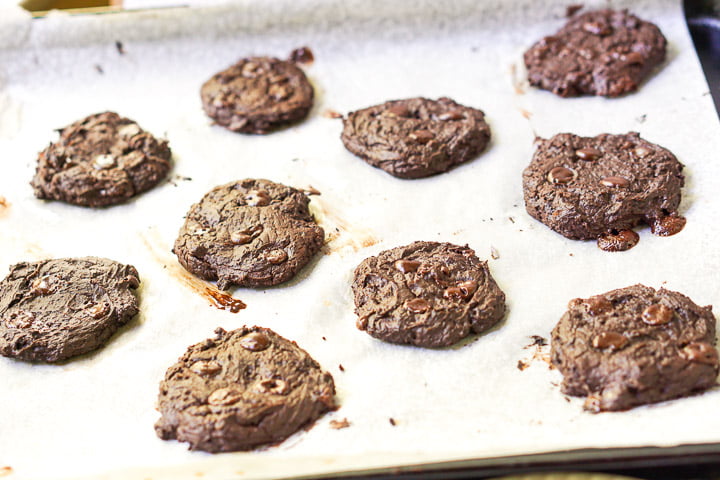 baked sugar free brownie cookies on a parchment covered cookie sheet