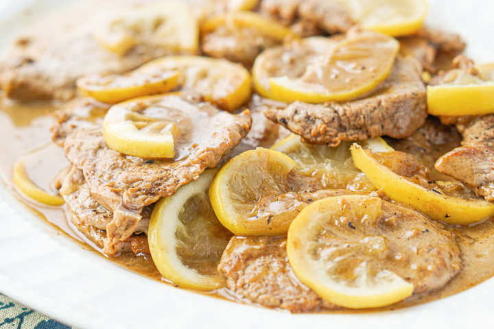 closeup of platter of pork medallions in lemon sauce