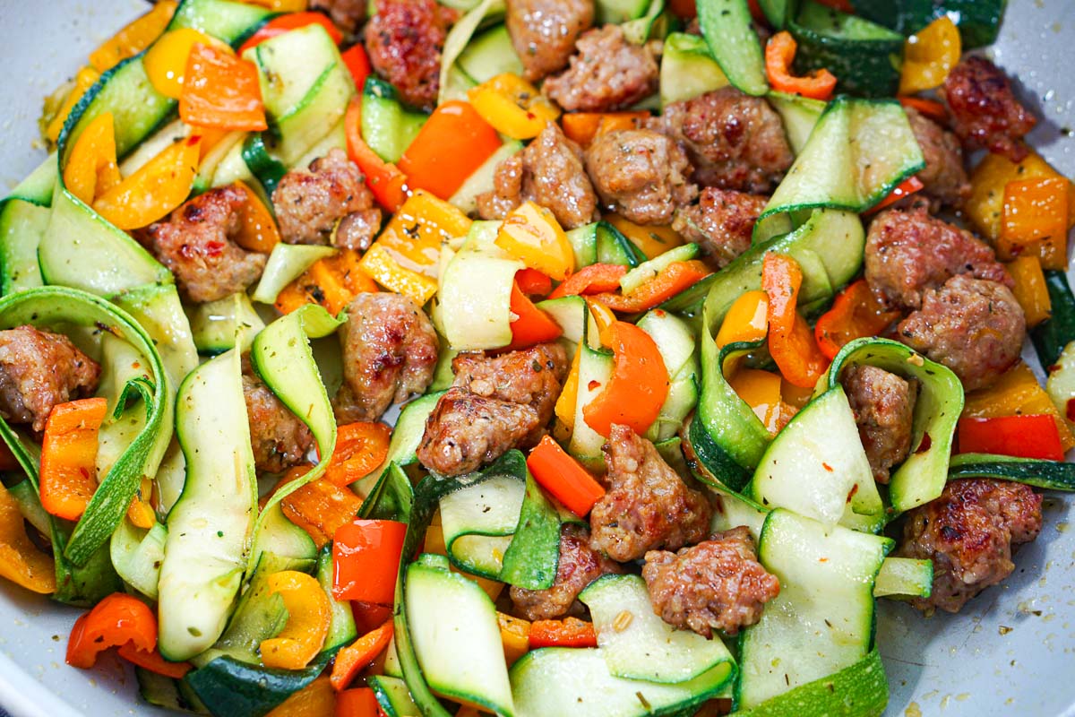 Closeup of the pan of the finished zoodles, Italian sausage and vegetables.