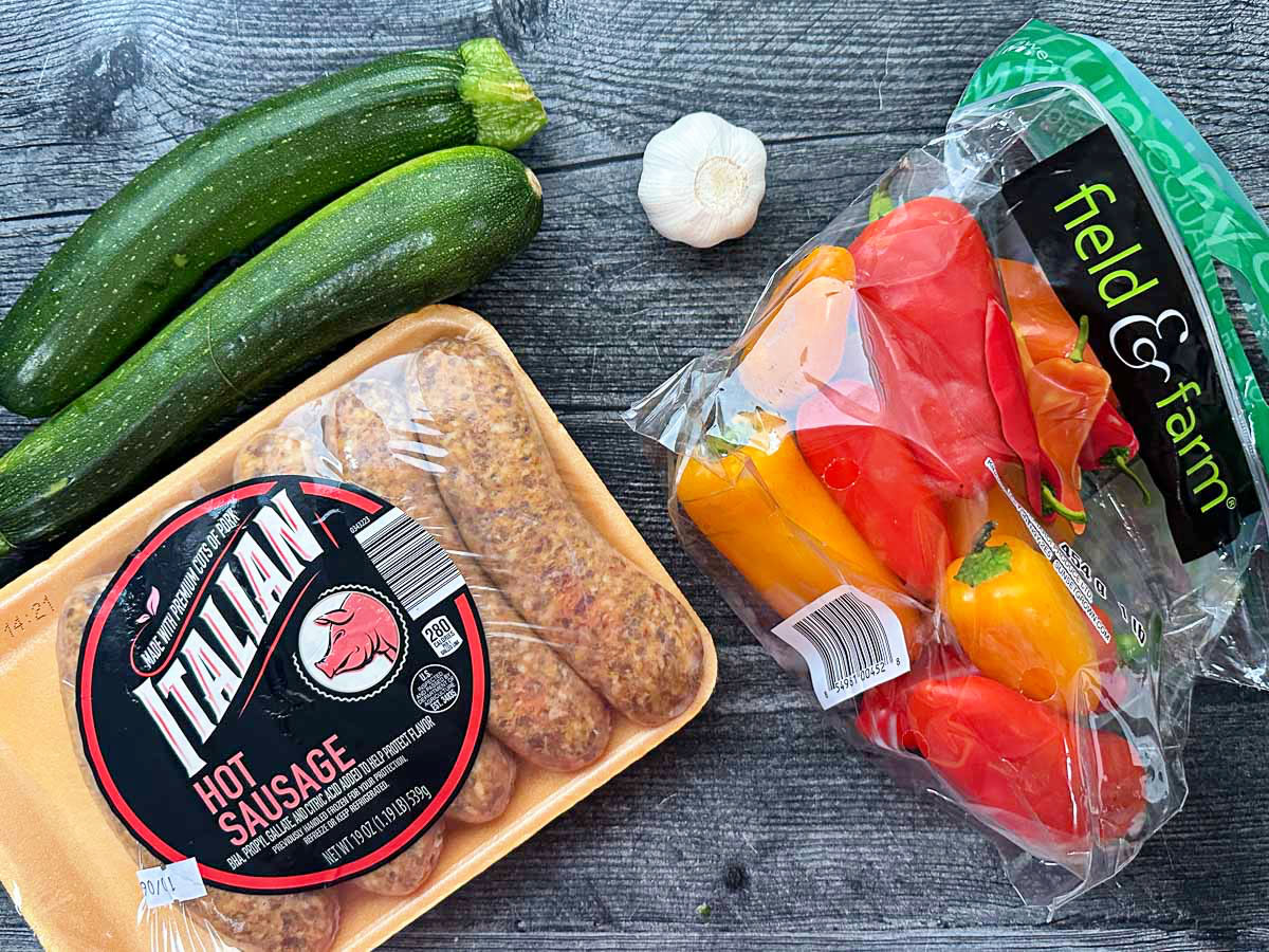 Recipe ingredients - peppers, garlic, zucchini, and hot sausage.
