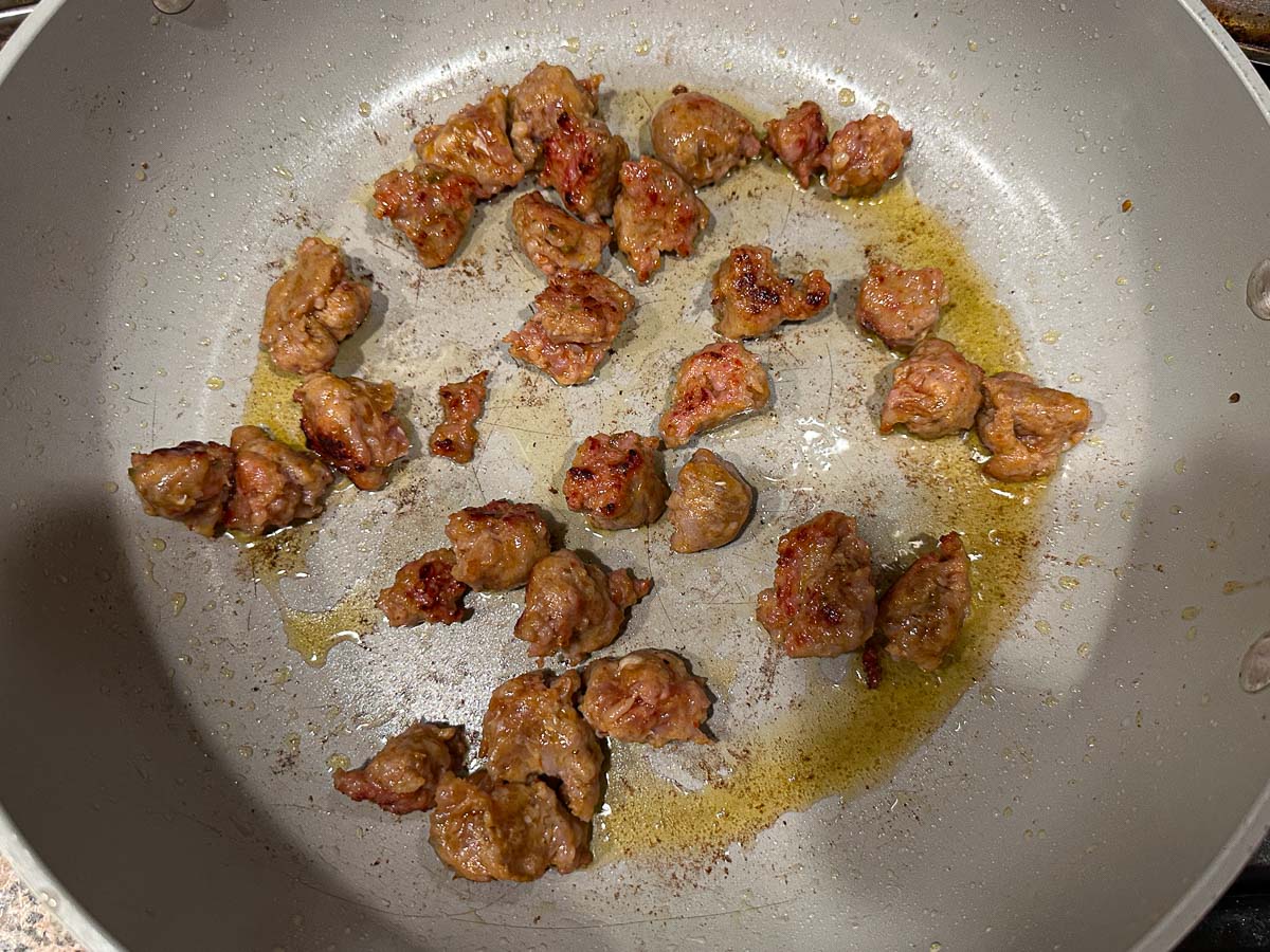 Large pan with browned sausage pieces.