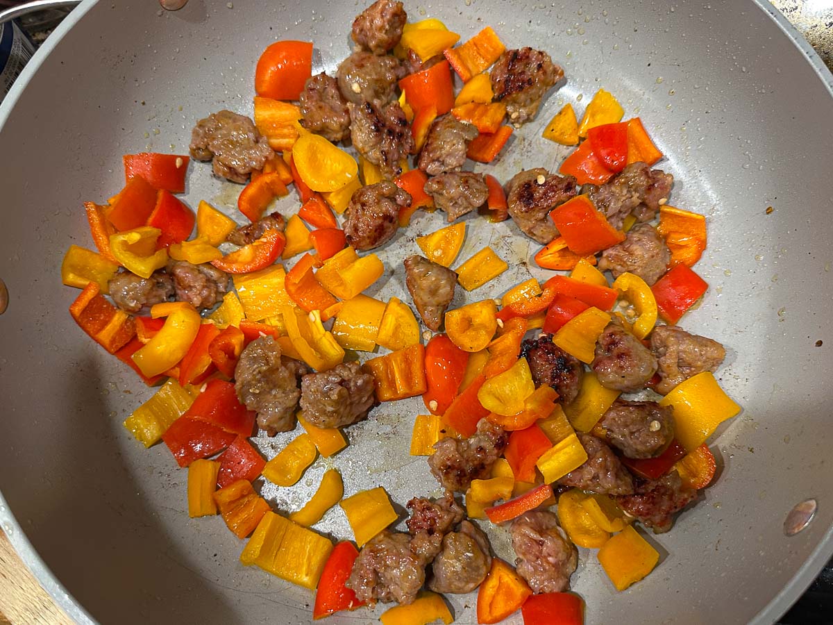 Saute pan with browned sausage and sweet bell peppers.