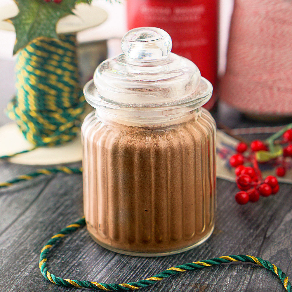 glass decorative jar with keto hot chocolate mix and Christmas decoration sin the background