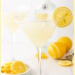 two lemon drop martinis with Absolut vodka bottle and lemons with text