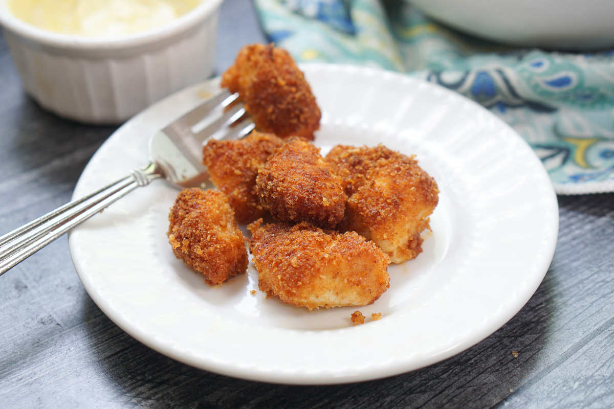 white plate with a few keto chicken nuggets and fork