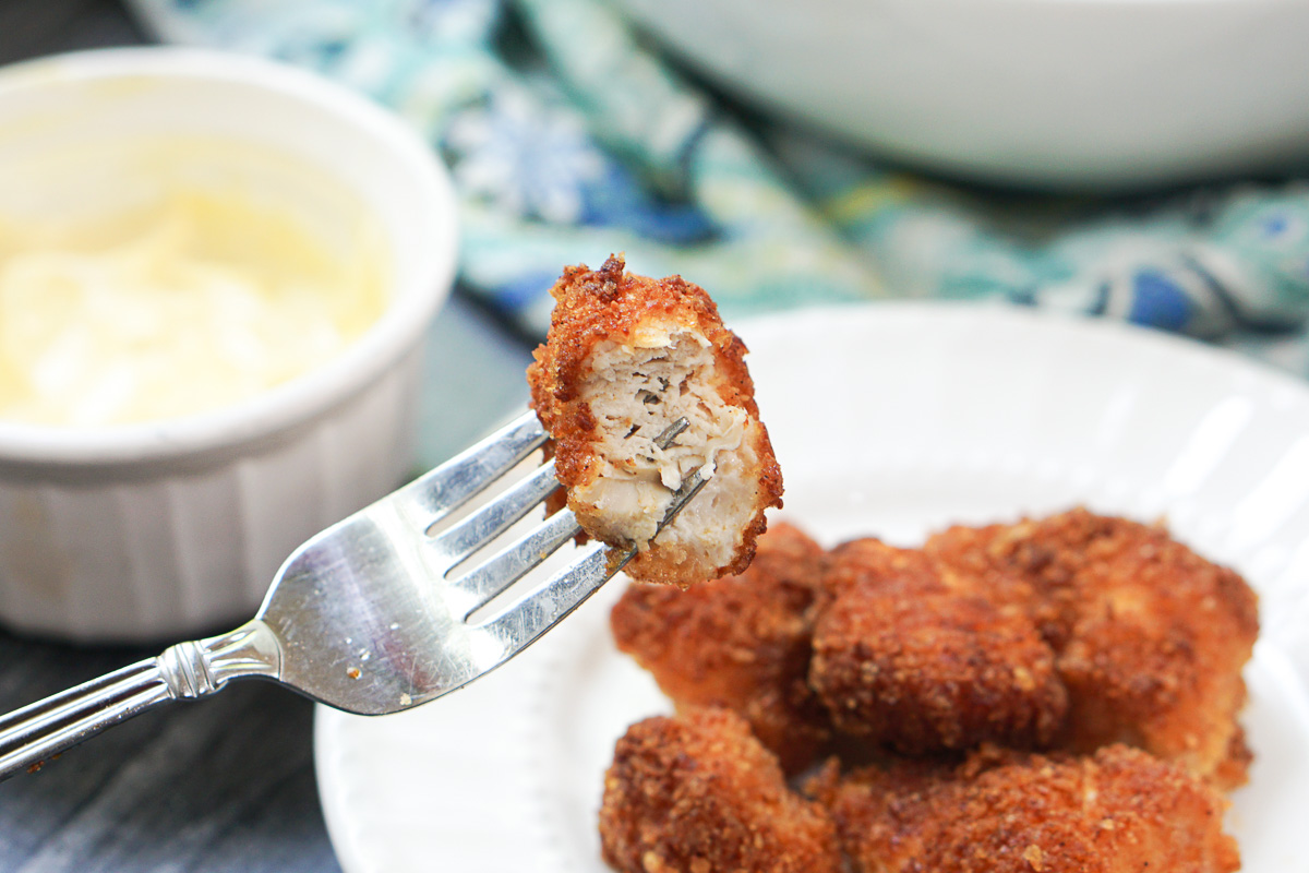 a fork with a bite of keto breaded chicken pieces