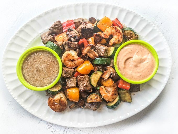 White platter with hibachi steak bites and two sauces.